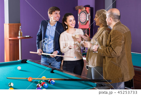 Adults with wine at billiard table. Adults with wine at billiard table. 45253733