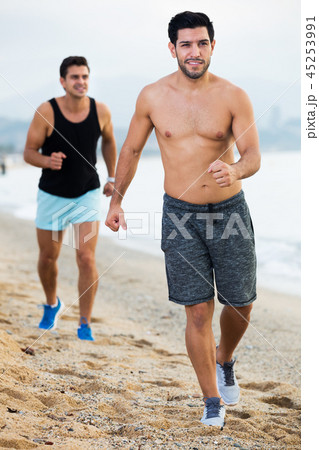 Two sportsmen jogging on beach Two sportsmen jogging on beach 45253991