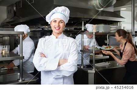 Portrait of young confident woman chef in kitchen of restaurant Portrait of young confident woman chef in kitchen of restaurant 45254016