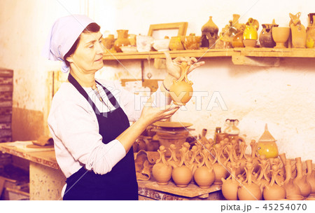 Mature master among the pottery at the workshop 45254070