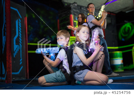 Kids sitting back to back with laser guns Kids sitting back to back with laser guns 45254756