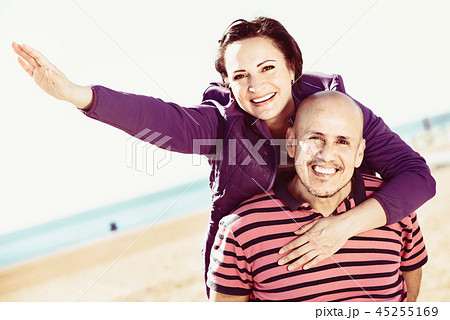 Couple gladly hugging each other and enjoying the beach Couple gladly hugging each other and enjoying the beach 45255169