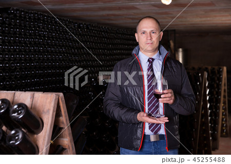 Winemaker offering red wine for tasting Winemaker offering red wine for tasting 45255488