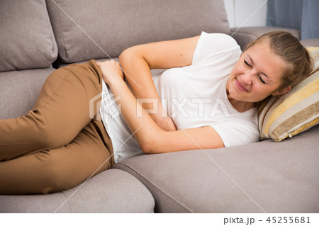 Girl is lying unhappy because she has a stomach ache 45255681