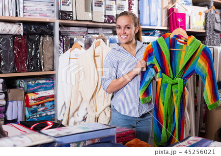 Young female customer looking through bathrobes Young female customer looking through bathrobes 45256021