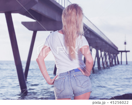 Cheerful female is posing on the rocks in her free time Cheerful female is posing on the rocks in her free time 45256022