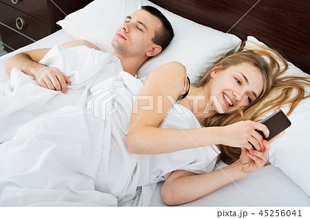 Beautiful young wife texting with lover on smartphone 45256041