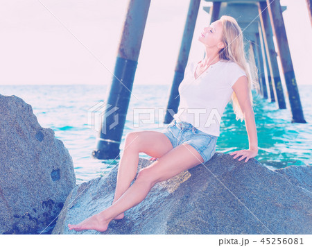 Female is posing on the rocks in her free time Female is posing on the rocks in her free time 45256081