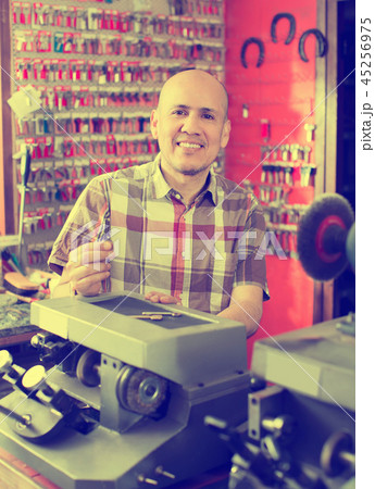 Workman making duplicates of keys . Workman making duplicates of keys . 45256975