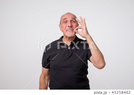 Keeping quiet and silence concept. Concept of mature amn zipping or closing his mouth 45258402