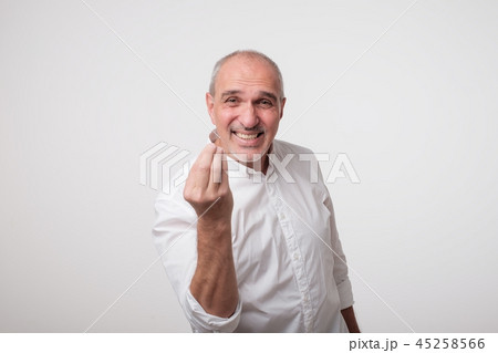 Bald handsome mature man looking angry showing italian gesture over white background. 45258566
