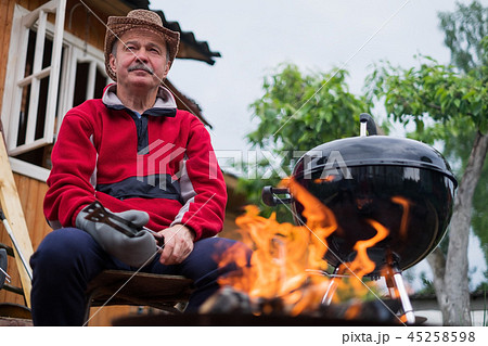 Barbecue time. European man in hat waiting for grilled food. Barbecue time. European man in hat waiting for grilled food. 45258598