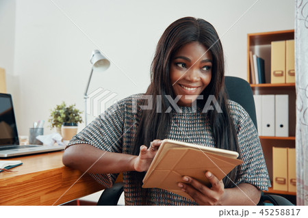 Smiling black woman with tablet in office 45258817