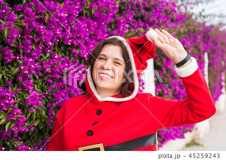 Christmas, holidays, humor and people concept - young happy woman smiling in christmas suit at 45259243