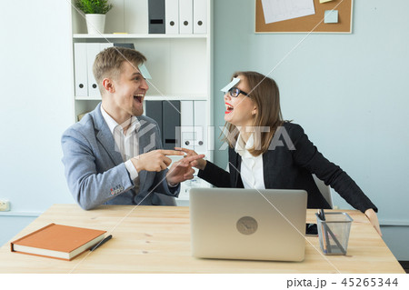 Business, break and people concept - Cheerful man and woman playing games in office while working 45265344