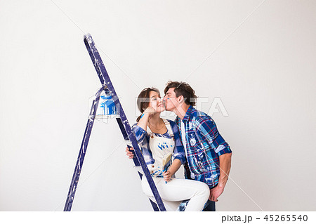 People, renovation and repair concept - young couple doing a redecoration and kissing in new 45265540
