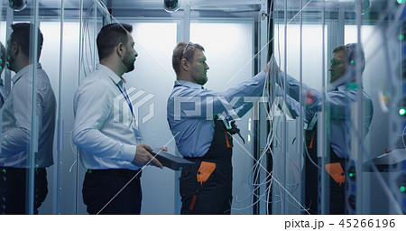 Two men performing maintenance in a data center Two men performing maintenance in a data center 45266196