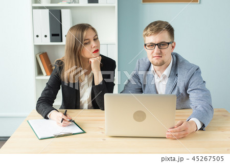 Business, teamwork and people concept - Two colleague discussing some interesting project in office Business, teamwork and people concept - Two colleague discussing some interesting project in office 45267505