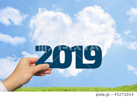 2019年を持つ男性の手と青空とハート型の雲と草原背景 2019年を持つ男性の手と青空とハート型の雲と草原背景 45271014