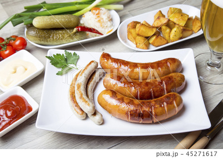 Grilled sausages with vegetables and sauces Grilled sausages with vegetables and sauces 45271617