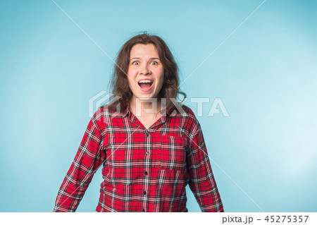 Emotions and people concept - Excited happy woman on blue background Emotions and people concept - Excited happy woman on blue background 45275357