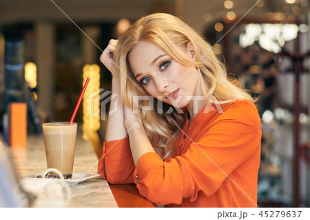 Beautiful blonde girl sitting in a cafe 45279637