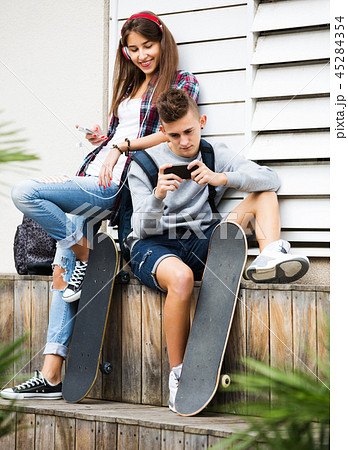 Teenage relaxing with mobile phones 45284354