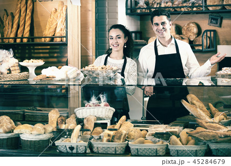 Bakery staff offering bread and different pastry 45284679