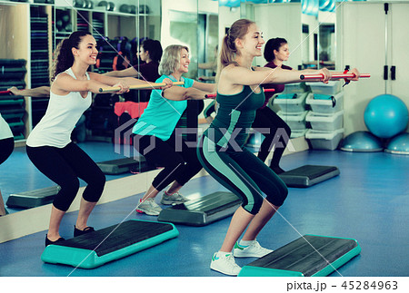 Females working out on aerobic step platform 45284963