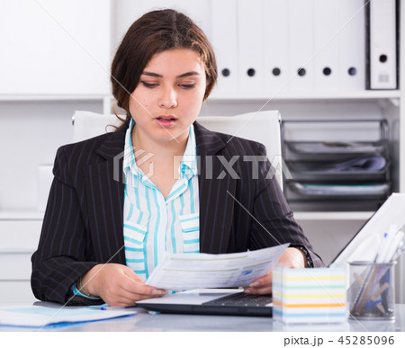 Office manager woman is reading documents about the transaction Office manager woman is reading documents about the transaction 45285096