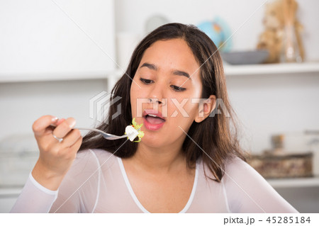 Positive young female eating salad Positive young female eating salad 45285184