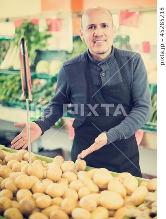 Man selling potatoes in farm food store. 45285218