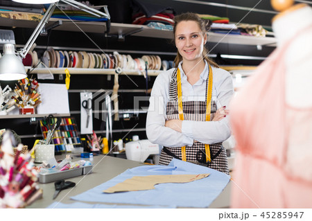 Positive tailor working with marker for modeling clothes at workshop 45285947