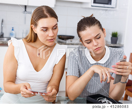 Girls reading manual of new smartphone 45286083