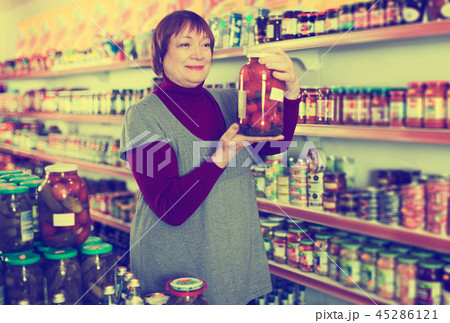 female consumer holding glass jar of tomatoes female consumer holding glass jar of tomatoes 45286121