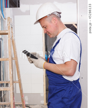 Smiling workman using phone Smiling workman using phone 45286133