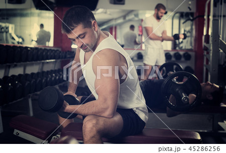 Guy during workout in gym with dumbbells 45286256
