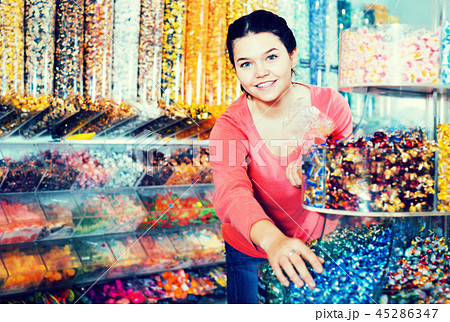 Girl choosing sweets in shop 45286347