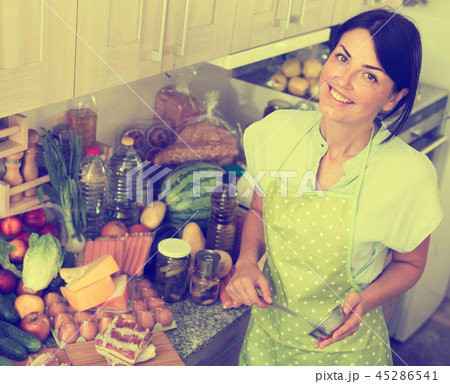 Cheerful woman is posing in time cooking on the kitchen Cheerful woman is posing in time cooking on the kitchen 45286541