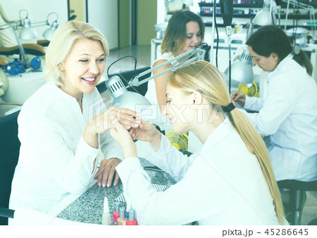 Female clients doing nails in nail salon in afternoon Female clients doing nails in nail salon in afternoon 45286645
