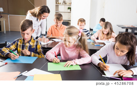 smiling little kids with teacher drawing in classroom 45286708