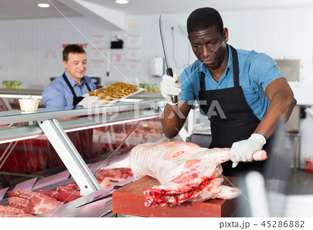 Butcher cutting lamb carcass Butcher cutting lamb carcass 45286882