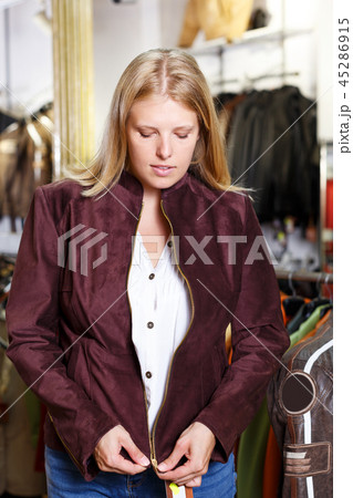 woman trying on clothes in leather outerwear shop 45286915