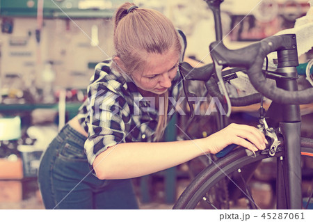 Portrait of nice girl who is fixing her bicycle Portrait of nice girl who is fixing her bicycle 45287061