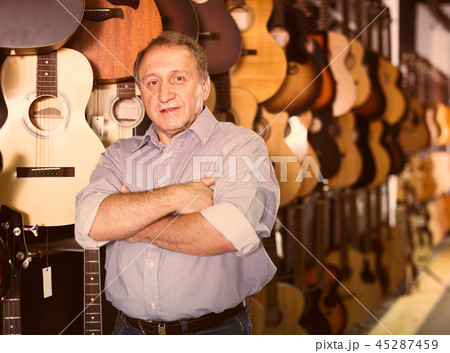 Mature man choosing acoustic guitar 45287459