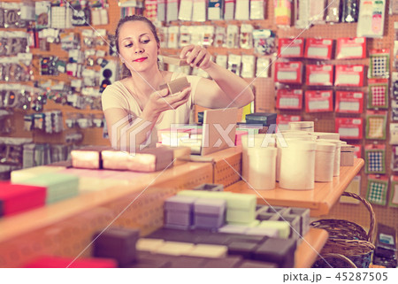 Young housewife is choosing small boxes for gifts Young housewife is choosing small boxes for gifts 45287505
