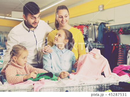 family with two girls choosing new clothes family with two girls choosing new clothes 45287531