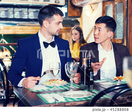 Two businessmen are having dinner in the restaurante Two businessmen are having dinner in the restaurante 45288808