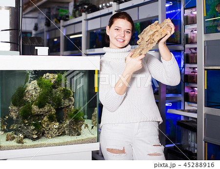 Teenager demonstrates stones for aquariums 45288916