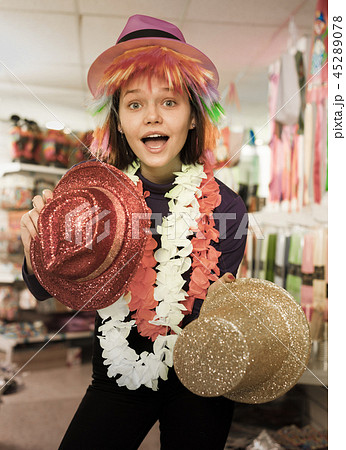Woman choosing funny headdresses in store Woman choosing funny headdresses in store 45289078